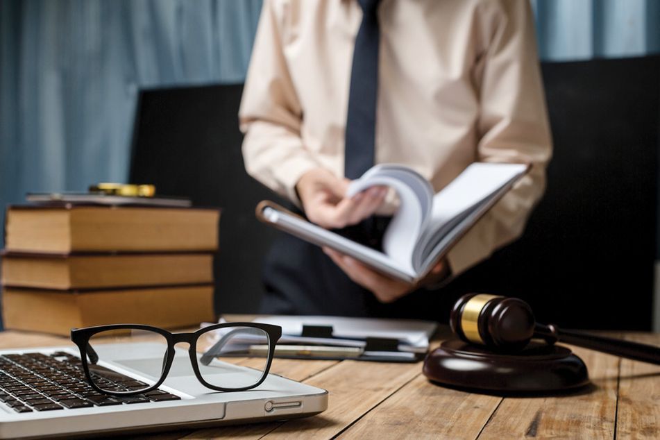 glasses-gavel-on-desk-with-man-reading-a-book