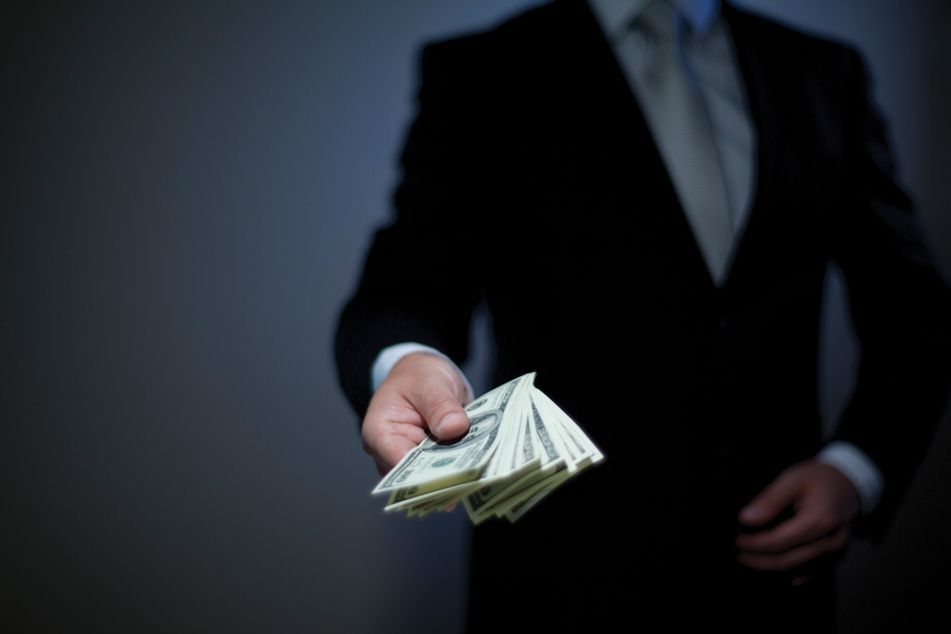 Man in suit holding cash