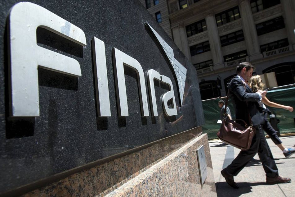 people walk past Finra sign