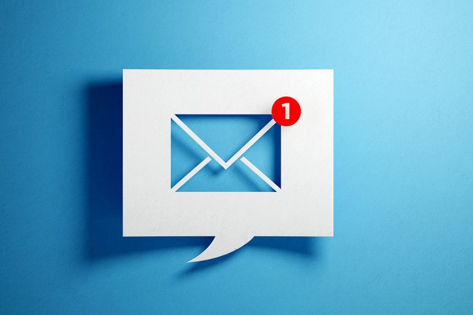 White chat bubble with email symbol on blue background. Horizontal composition with copy space