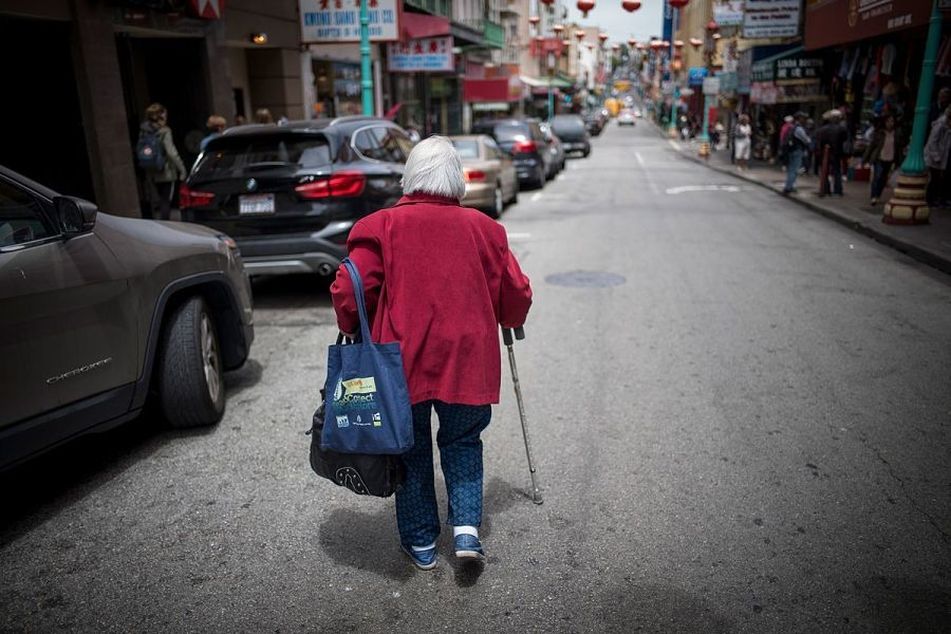 Older-woman-with-cane-walks-down-street