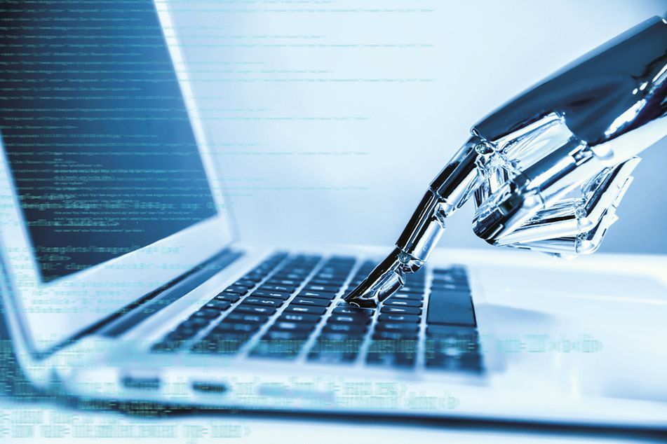 Robotic hand presses key on laptop keyboard
