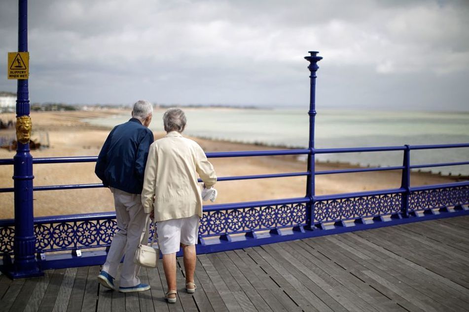 older-couple-walking-on-boardwalk