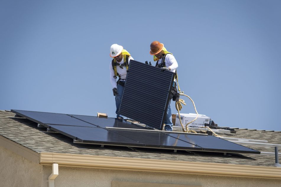 workers-installing-solar-panels-on-roof