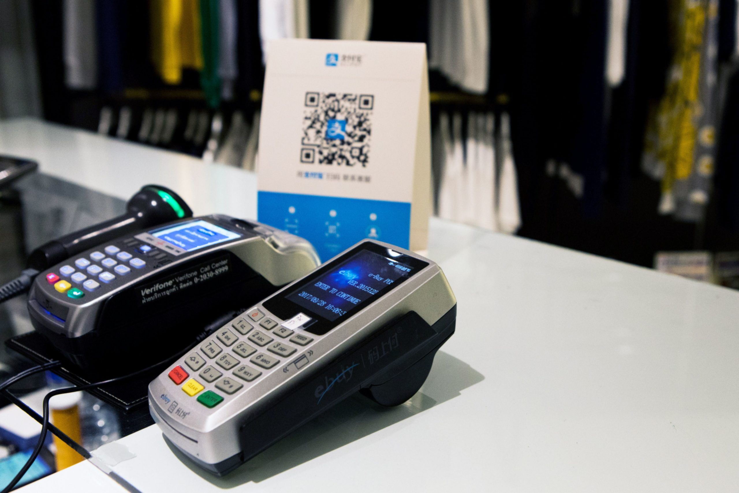 Credit Card readers sit next to a sign for Ant Financial Services Group's Alipay, an affiliate of Alibaba Group Holding Ltd., at the check out counter of a store 