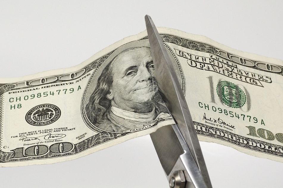 Hundred Dollar Bill Being Cut With a Scissor
