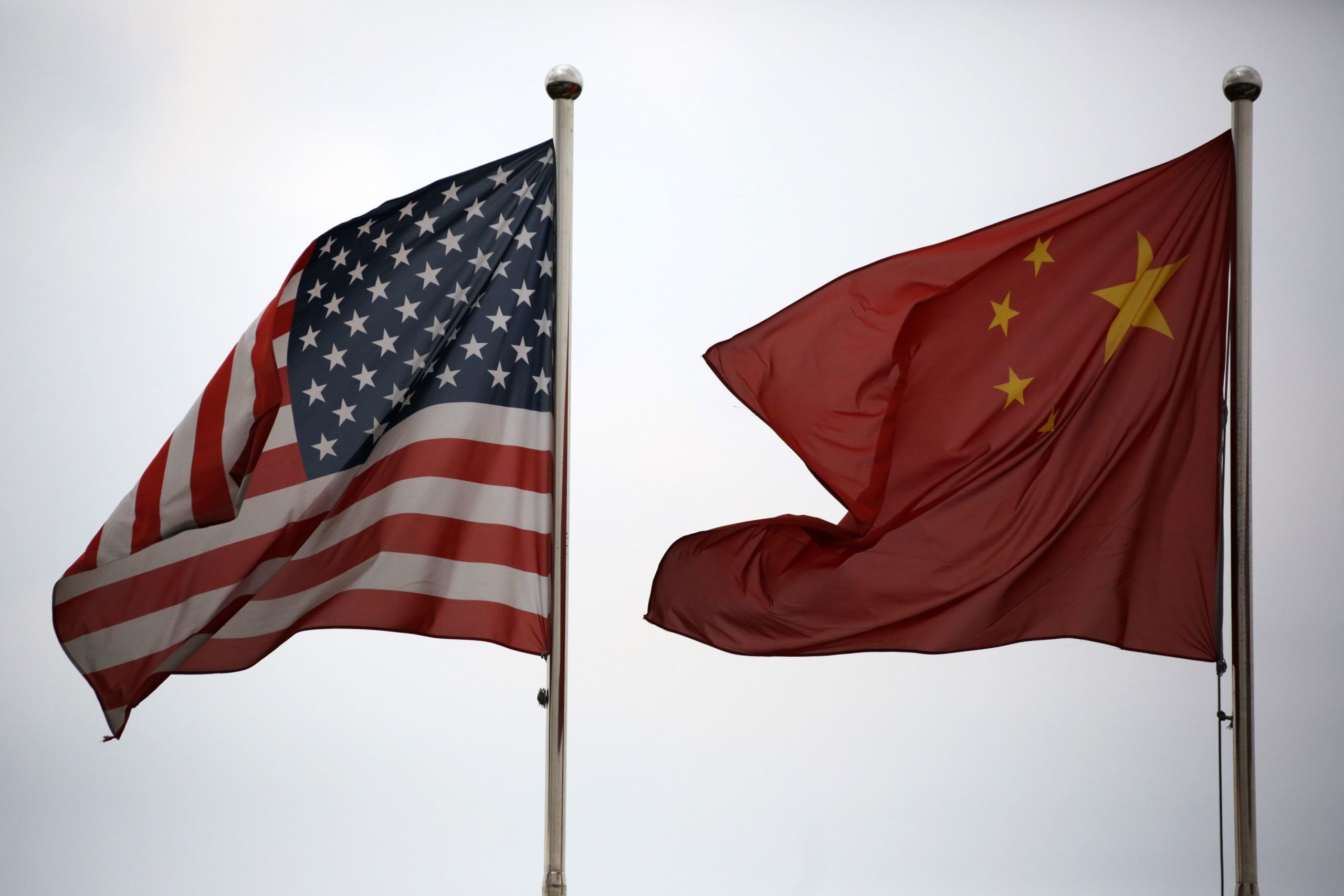 U.S. and Chinese national flags fly outside a company building.