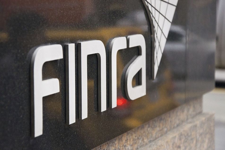 Finra logo on wall by sidewalk