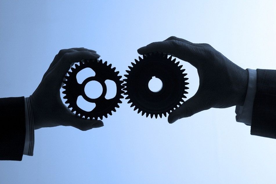 two people holding gears side by side