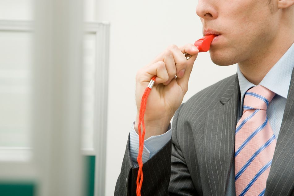 Man in suit blowing a whistle