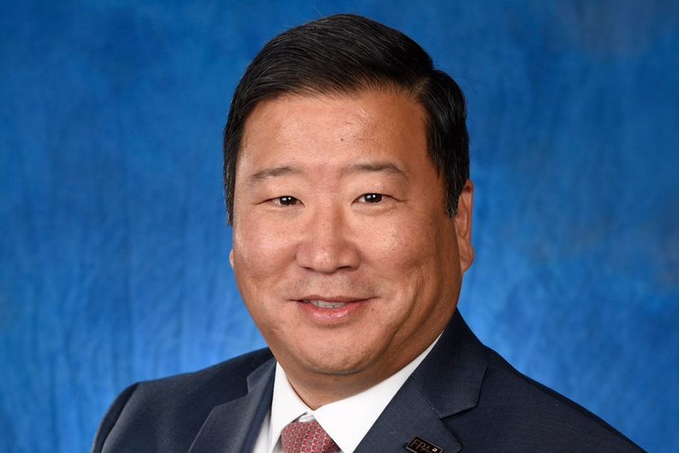 FPA president James Lee in a suit on blue background