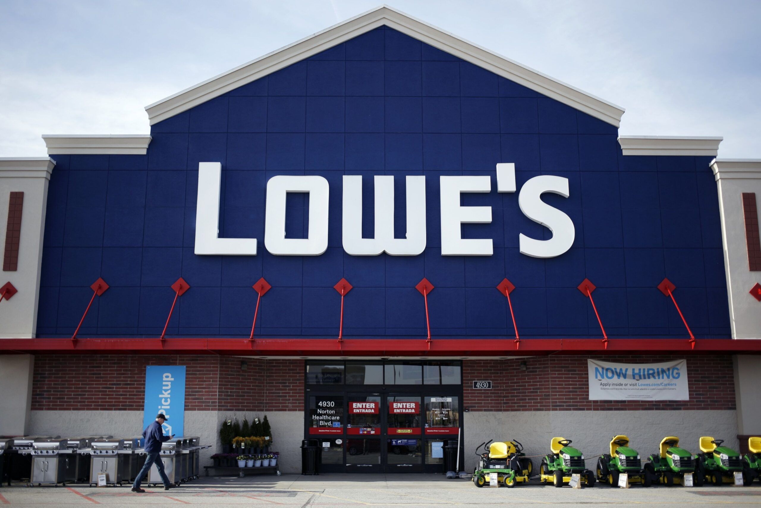 A customer walks towards the entrance to a Lowe's Cos. store in Louisville, Kentucky, U.S. It was a cold winter for Lowe's Cos., but sales largely held up. And now, Chief Executive Officer Marvin Ellison said demand for home improvement goods is starting to heat up, one day after rival Home Depot Inc. reported results that fell short. Photographer: Luke Sharrett/Bloomberg