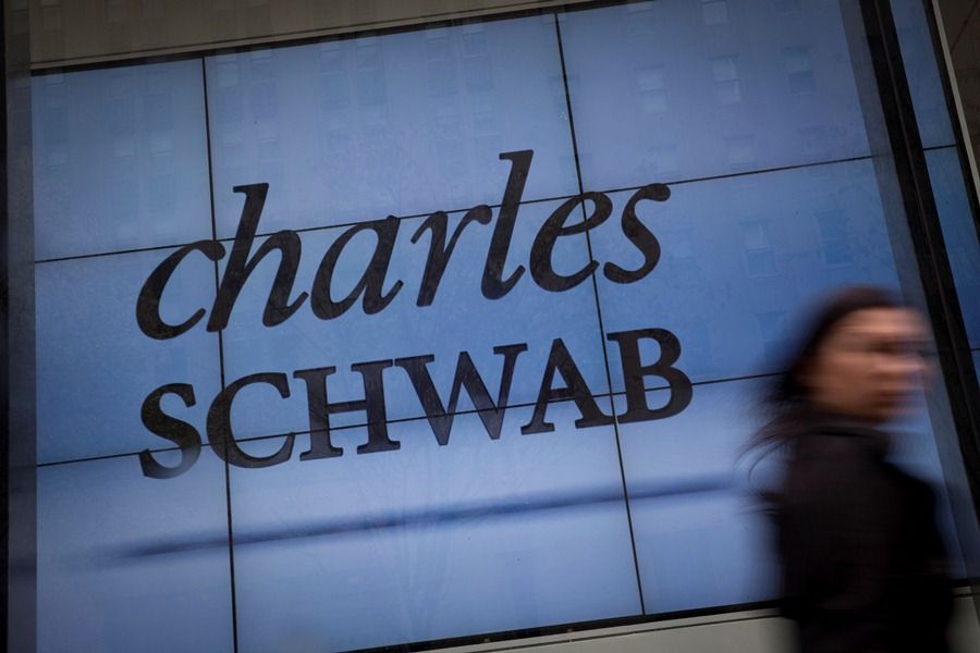 A pedestrian walks past a Charles Schwab Corp. office in New York, U.S., on Friday, April 12, 2013. Charles Schwab Corp., is a financial services firm with $1.89 trillion in client assets. Photographer: Scott Eells/Bloomberg