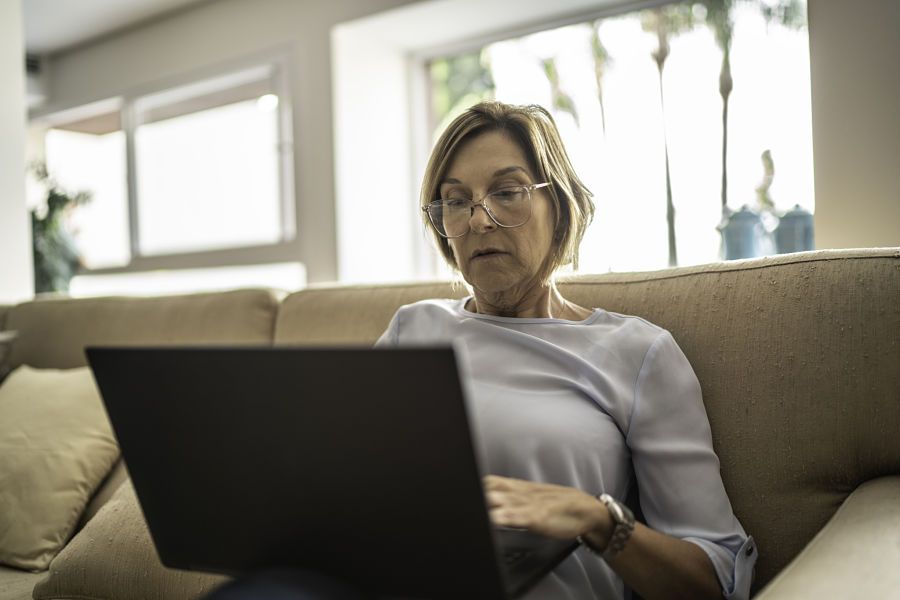 Mature woman using laptop in the living room