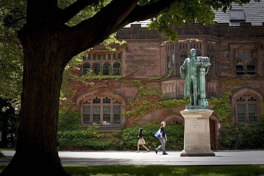 Pedestrians walk past a statue of former Princeton University president John Witherspoon near the East Pyne building on the school's campus in Princeton, New Jersey, U.S., on Monday, June 21, 2010.  Photographer: Emile Wamsteker/Bloomberg
