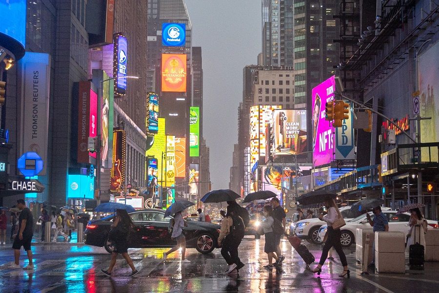 People walk in the rain in Times Square in New York City, New York, U.S., July 6, 2021. REUTERS/Jeenah Moon