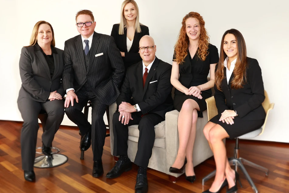 James, Ford & Duble Wealth Partners with support staff sitting in suits.